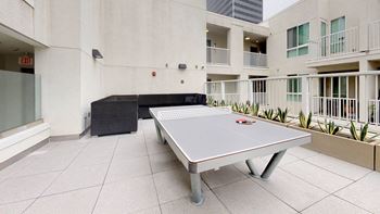 A ping pong table on the patio of an apartment building 